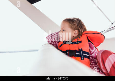 Close-up de 3 ans, fille en gilet orange sur un bateau à moteur, la Suède Banque D'Images