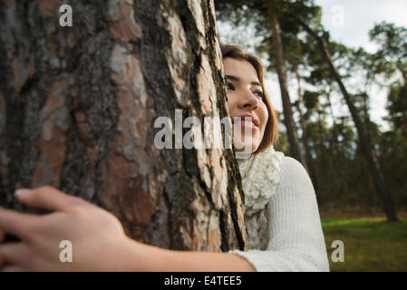 Young Woman Hugging Tree Trunk, Mannheim, Baden-Wurttemberg, Germany Banque D'Images