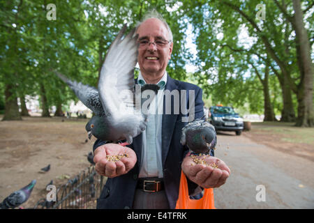 Nourrir les oiseaux l'homme local dans St James's Park à Londres Banque D'Images