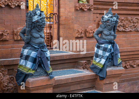 Jimbaran, Bali, Indonésie. Hindu Temple Guardian portant Saput Poleng, un tissu à carreaux noirs et blancs. Banque D'Images