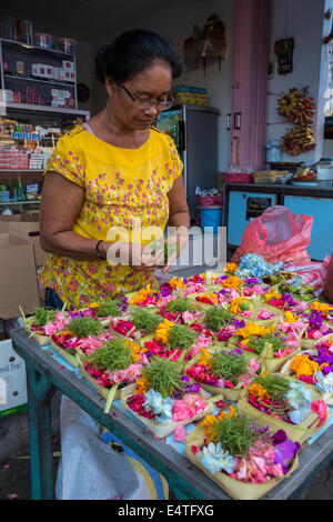 Bali, Indonésie. L'épargne (canang) faite par un spécialiste de l'épargne (banten tukang) à vendre. Banque D'Images