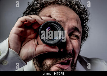 Avec objectif photographe, l'homme avec l'expression intense, chemise blanche Banque D'Images