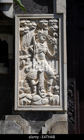 Jimbaran, Bali, Indonésie. Chiffres hindou traditionnel en pierre, flanqué d'entrée d'une maison privée. Banque D'Images