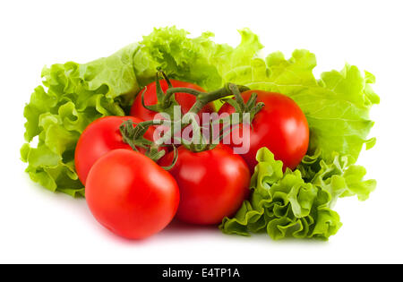 Tomates mûres sur des feuilles de salade verte Banque D'Images