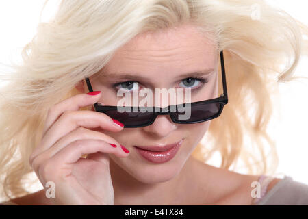 Blonde woman peering over ses lunettes de Banque D'Images