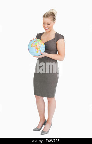 Businesswoman looking at globe dans ses mains Banque D'Images