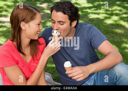 Woman feeding her friend ice cream Banque D'Images