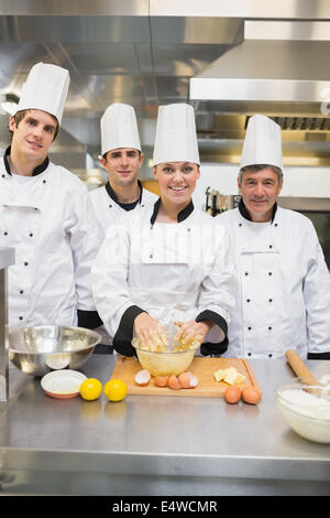 Les étudiants culinaires souriant avec professeur de pâtisserie Banque D'Images