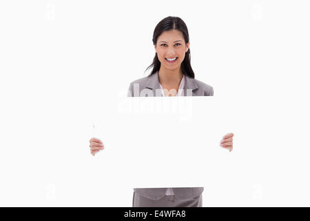 Smiling businesswoman with blank sign board Banque D'Images