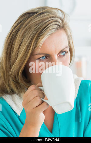 Woman in bathrobe drinking coffee Banque D'Images