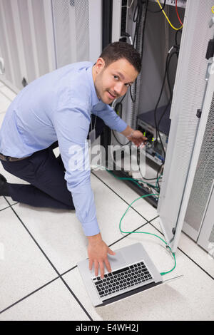 Technicien en souriant l'insertion d'une clé USB Banque D'Images