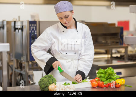 Chef slicing up oignons de printemps Banque D'Images