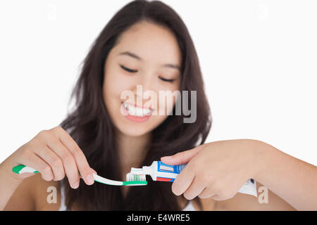 Femme de mettre du dentifrice sur une brosse à dents Banque D'Images