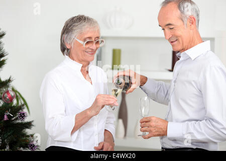 Vieux couple drinking champagne Banque D'Images