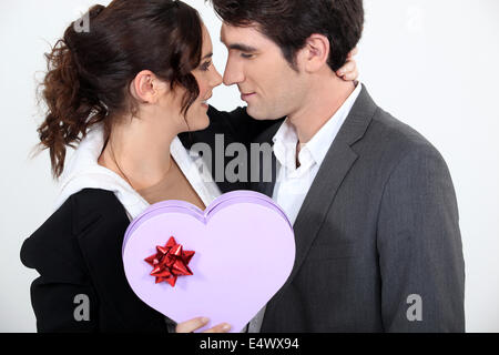 Couple holding heart-shaped box of Chocolates Banque D'Images