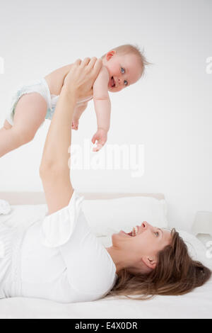 Happy woman holding son bébé en position couchée Banque D'Images