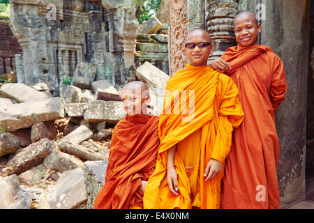 3 moines jouant avec les lunettes de soleil à Ta Prohm temple au Cambodge Banque D'Images