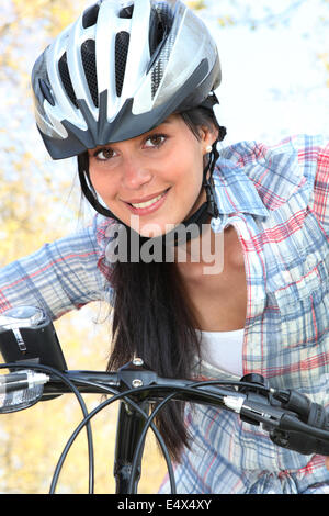 Young woman riding bike dans le parc Banque D'Images