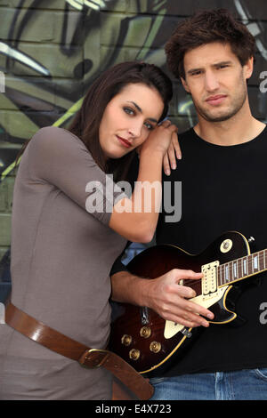 Couple avec guitare en avant du mur peint Banque D'Images