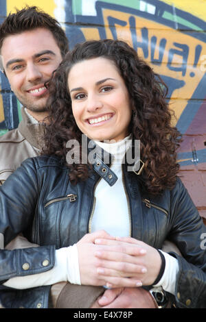 Couple standing in front wall Banque D'Images