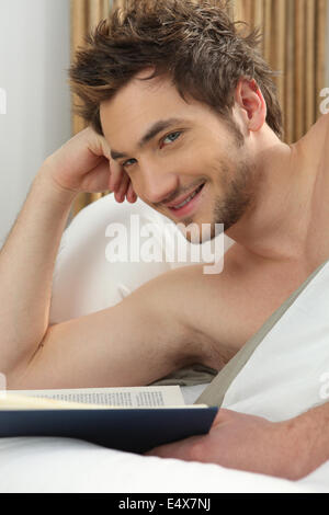 Man reading in bed Banque D'Images