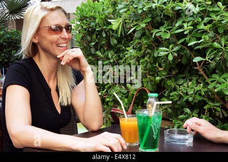 Couple assis sur terrasse potable Banque D'Images