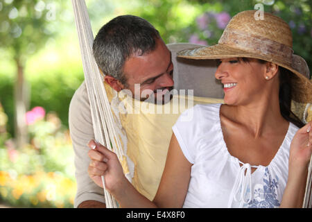 Couple assis dans un hamac Banque D'Images