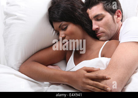 Mari et femme se blottir dans le lit Banque D'Images
