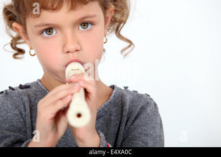 Little girl playing flute Banque D'Images