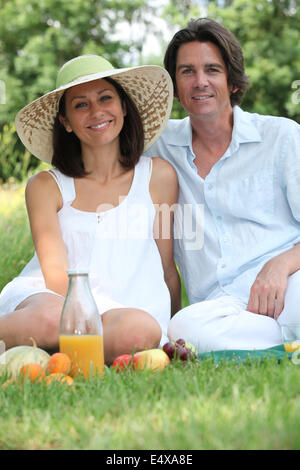 Couple assis sur l'herbe Banque D'Images