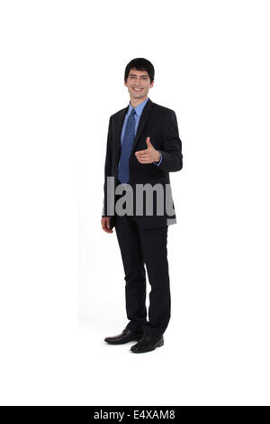 Young businessman giving thumbs-up geste Banque D'Images