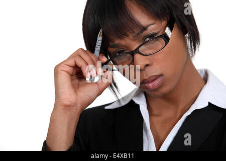 Stern businesswoman touching ses lunettes Banque D'Images