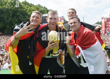 Document - de l'Allemagne Bastian SCHWEINSTEIGER, P. MERTESACKER, Torwart Manuel NEUER et Kevin Grosskreutz célébrer avec le trophée de la Coupe du monde lors de la Coupe du monde de travail à la porte de Brandebourg après l'Allemagne de l'équipe est arrivé en Allemagne à Berlin, Allemagne, 15 juillet 2014. L'équipe allemande a remporté le Brésil 2014 finale de la Coupe du Monde de soccer de la FIFA contre l'Argentine par 1-0 le 13 juillet 2014, remportant le titre de Coupe du monde pour la quatrième fois après 1954, 1974 et 1990. Photo : Markus Gilliar/GES/DFB/dpa (ATTENTION : Utiliser uniquement rédactionnel et crédit obligatoire "Photo : Markus Gilliar/GES/DFB/dpa') Banque D'Images