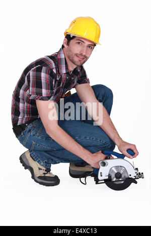 Homme avec une scie circulaire sur fond blanc Banque D'Images