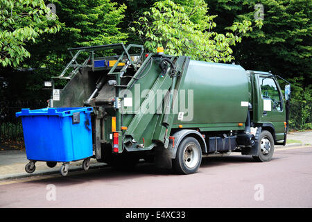 Camion Poubelle verte avec un représentant une poubelle bleue à l'arrière Banque D'Images