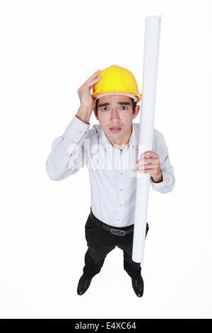 Ingénieur paniqué tenant un tapis d'encombrement Banque D'Images