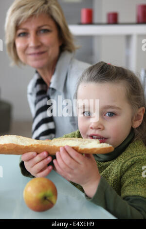 Little girl eating bread toast Banque D'Images