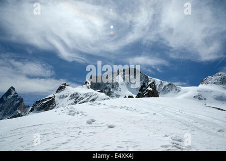 Grand soleil brille sur la neige d'un blanc au sommet d'une hutte de montagne sous un ciel bleu profond Banque D'Images