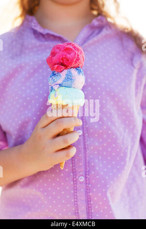 Girl holding ice cream cone dans ses mains Banque D'Images