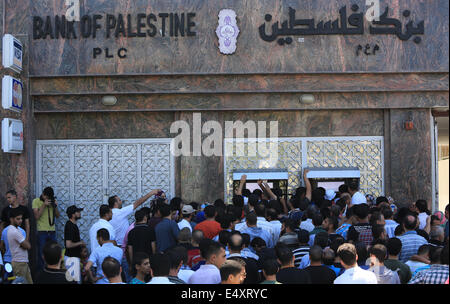 La bande de Gaza. 17 juillet, 2014. Essaim de Palestiniens de retirer leurs salaires à un distributeur automatique d'une banque pendant la durée de l'entente de cinq heures de cessez-le-feu humanitaire observée par Israël et le Hamas le 17 juillet 2014 dans la ville de Gaza. Au moins trois roquettes ont été lancées au sud d'Israël le conseil régional Eshkol le jeudi à midi, deux heures après les cinq heures de cessez-le-feu temporaire, les Forces de défense israéliennes (FDI). Source : Xinhua/Alamy Live News Banque D'Images