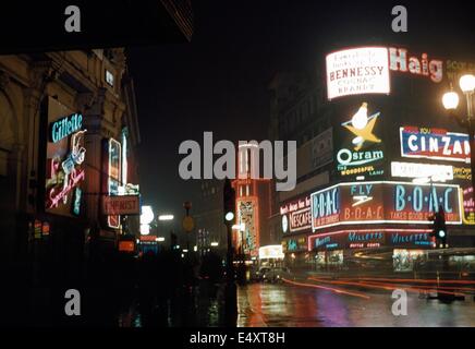 Les lumières et les panneaux publicitaires lumineux par nuit, Piccadilly, Londres, 1958. Banque D'Images