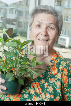Portrait of a senior woman with houseplant Banque D'Images