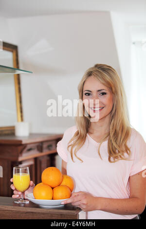 Smiling femme en bonne santé avec les oranges fraîches Banque D'Images