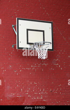 Basket hoop fixée sur un mur de brique rouge Banque D'Images