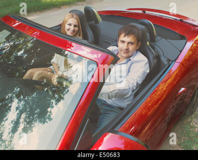 Heureux couple red cabriolet Banque D'Images