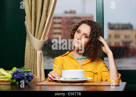 Jeune femme de manger une soupe au restaurant Banque D'Images