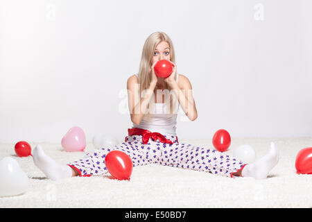 Femme blonde du gonflage des ballons Banque D'Images