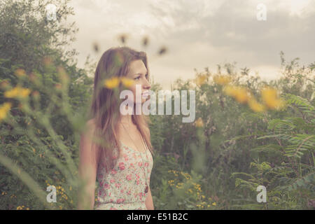 Belle jeune femme en prairie de fleurs. Banque D'Images