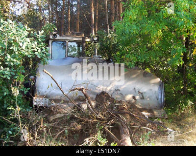 Vieux bulldozer efface un sentier dans les bois Banque D'Images