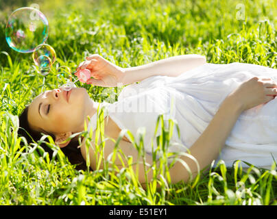 Beautiful pregnant woman relaxing on grass Banque D'Images